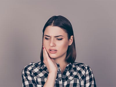 woman holding side of face