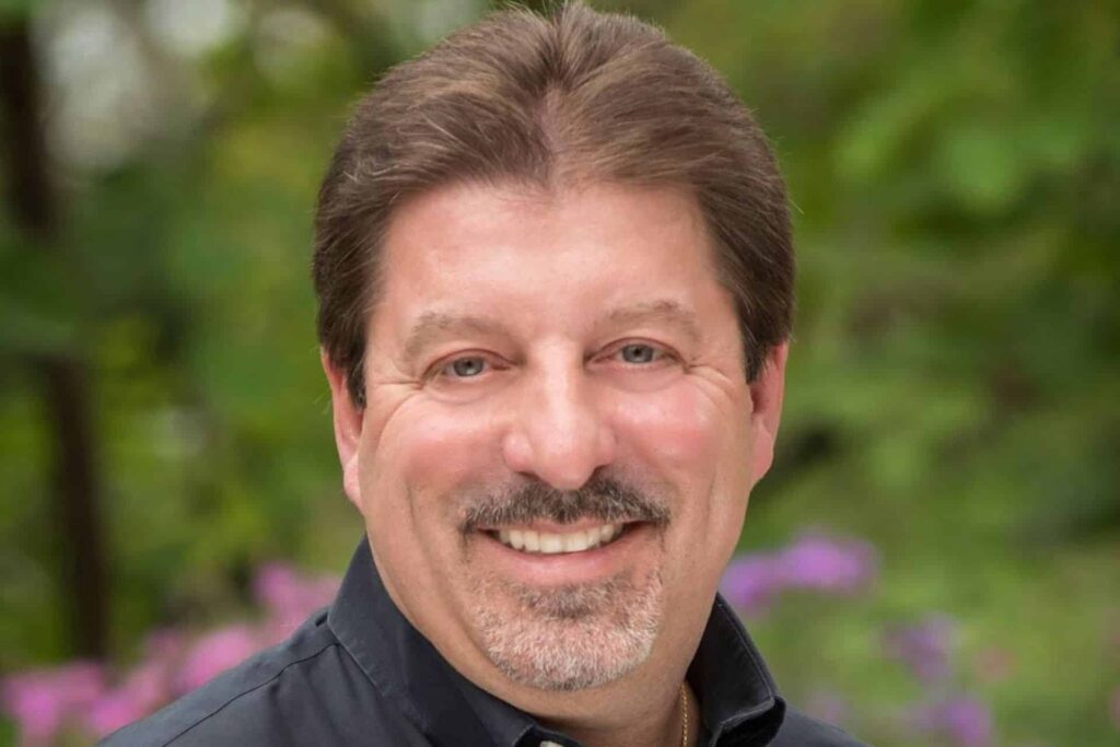 Smiling man with dark hair and mustache | Nudera Orthodontics