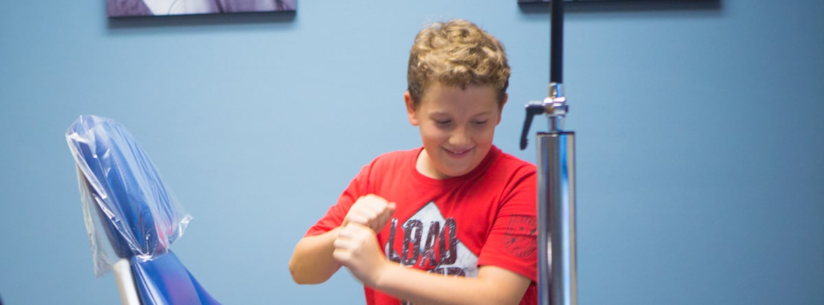 Young boy in red shirt smiling | Nudera Orthodontics